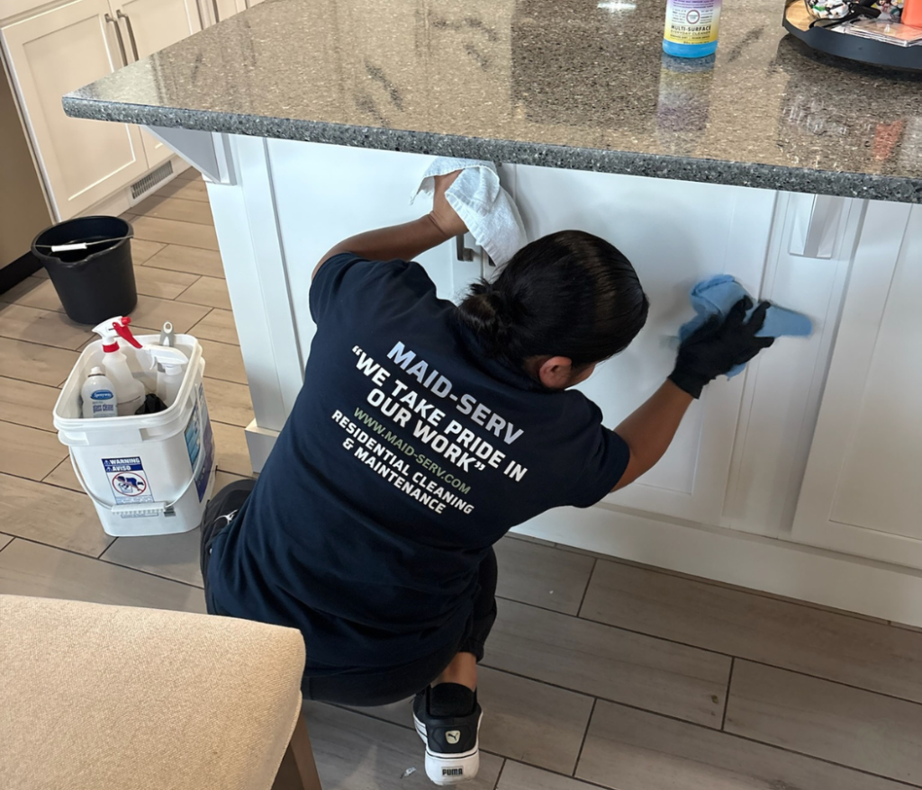 Maid-Serv cleaner wiping kitchen counter during house cleaning Salt Lake City cost