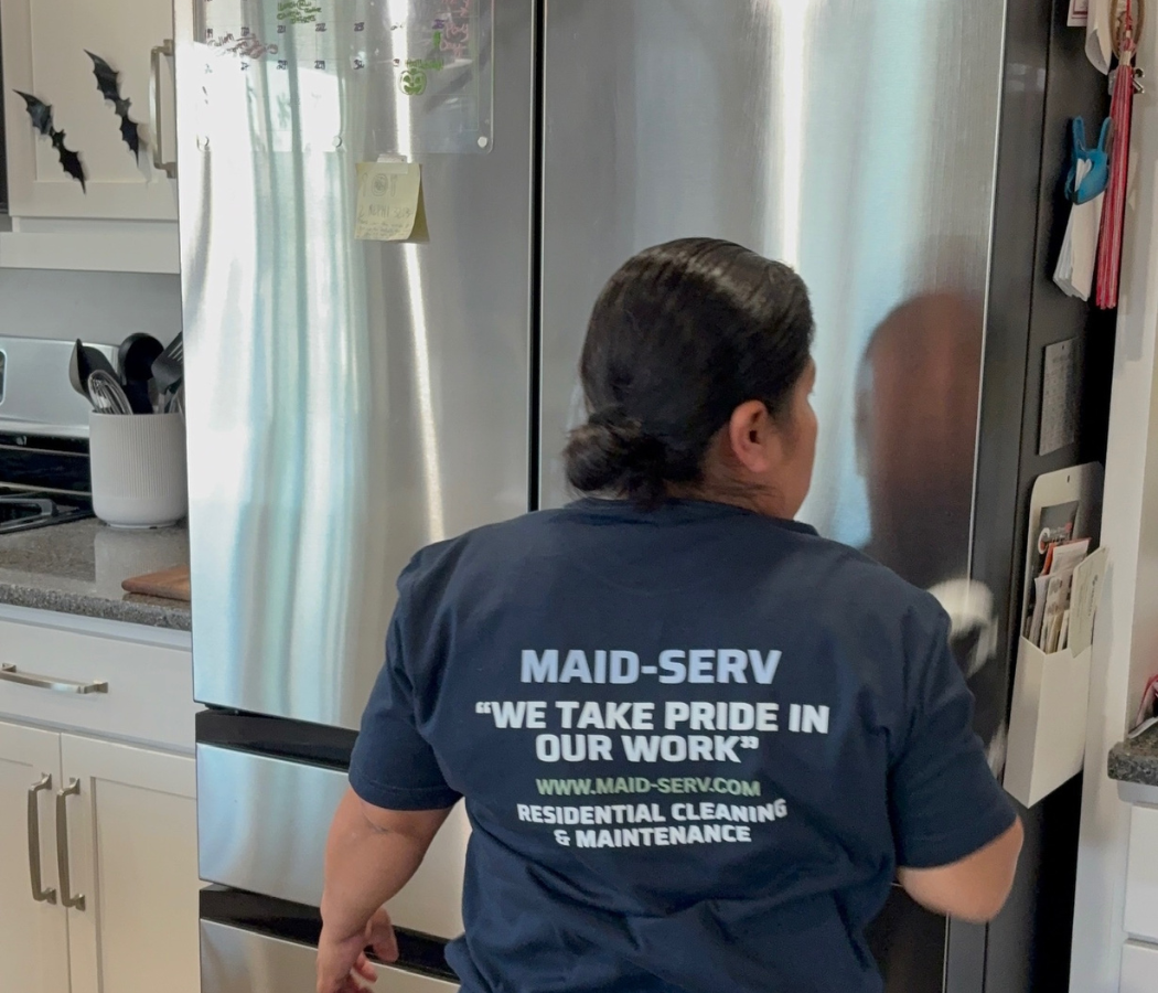Contact Maid-Serv Cleaning Services in Salt Lake, Utah, maid cleaning a refrigerator during a home cleaning service